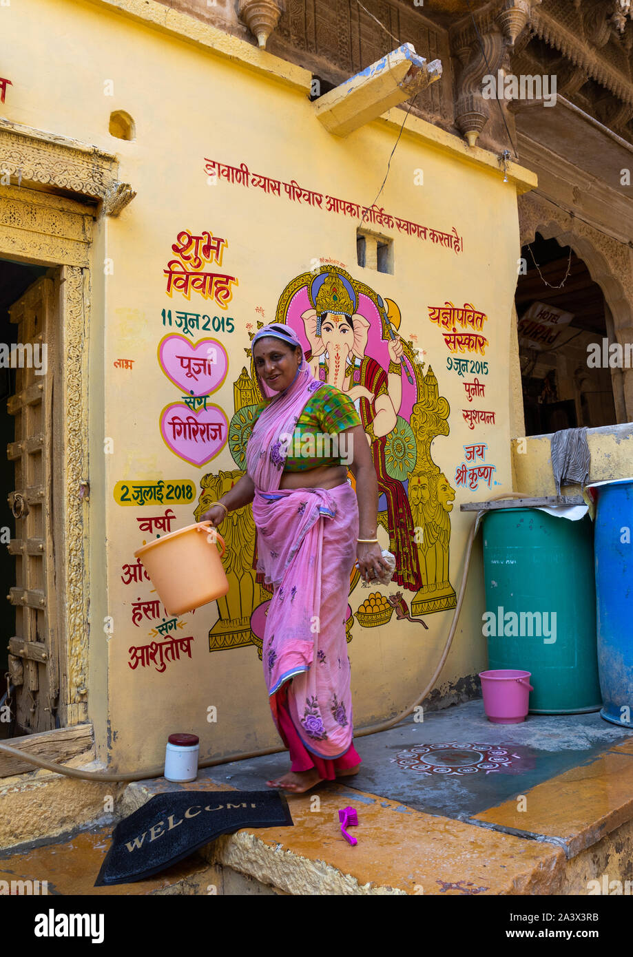 Portrait d'une femme en sari traditionnel rajasthani laver sa maison, Rajasthan, Jaisalmer, Inde Banque D'Images