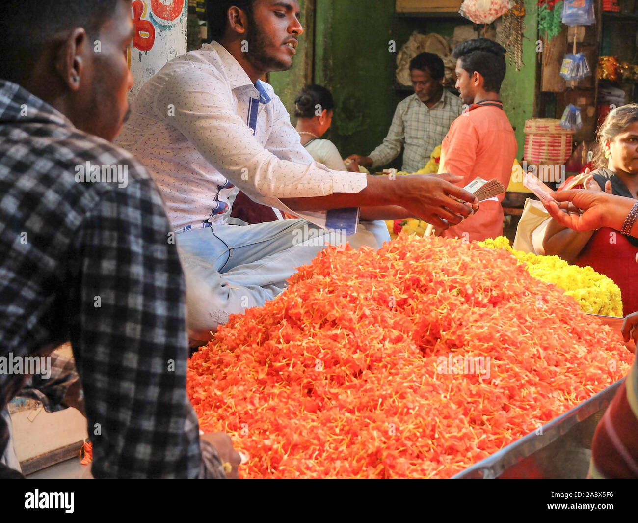 MYSURU (Mysore),KARNATAKA/Inde 13 FÉVRIER 2018:les vendeurs de fleurs et de l'argent change de mains, à l'étal de fleurs,Devaraja,marché,Karnataka Mysore. Banque D'Images