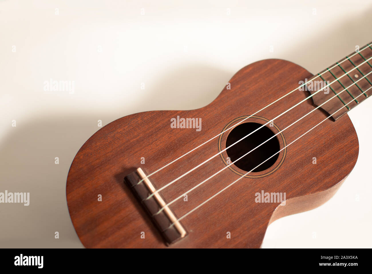 Ukulele bois avec fond isolé, vue avant, avec l'exemplaire de l'espace. Banque D'Images