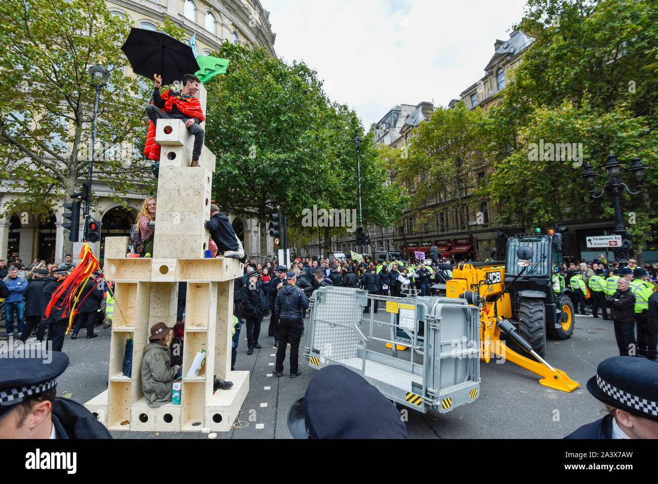 Londres, Royaume-Uni. 10 octobre 2019. JCB une grue arrive comme surround police une structure en bois, qui contient des garanties pour les militants, à Trafalgar Square pendant 4 jours d'Extinction Rebellion changement climatique protester dans la capitale. Les militants demandent au gouvernement de prendre des mesures immédiates contre l'impact négatif du changement climatique. Crédit : Stephen Chung / Alamy Live News Banque D'Images