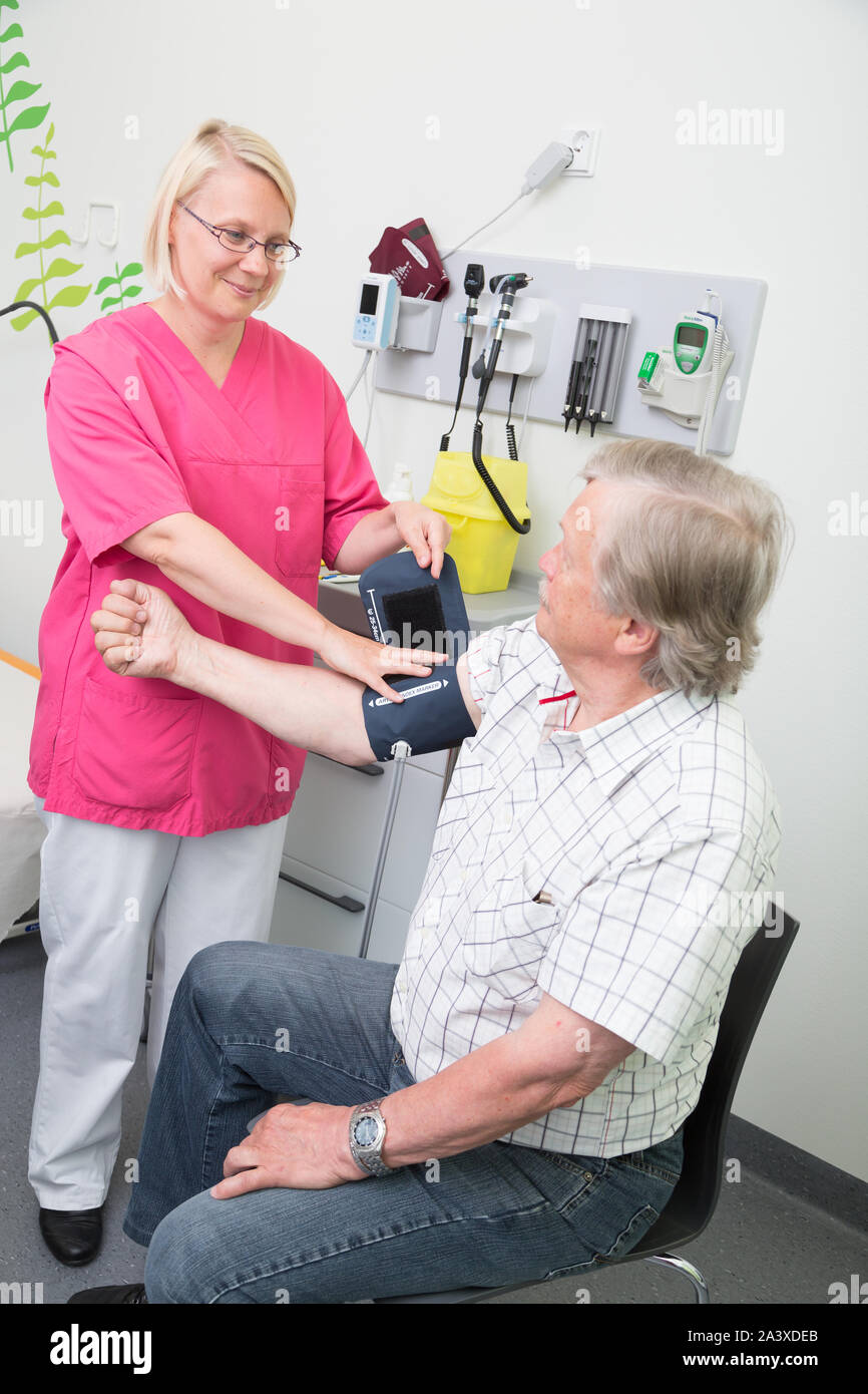 Femme infirmière autorisée la mesure de la pression artérielle d'un homme âgé dans un hôpital Banque D'Images