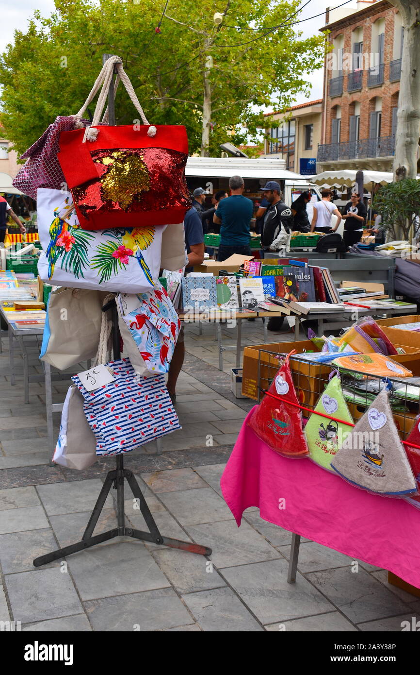 La mode féminine colorés de fin de plage tissu sacs à main en vente sur le marché local. Bâtiments en pierre, les étals de marché et d'arbre à l'arrière-plan Banque D'Images