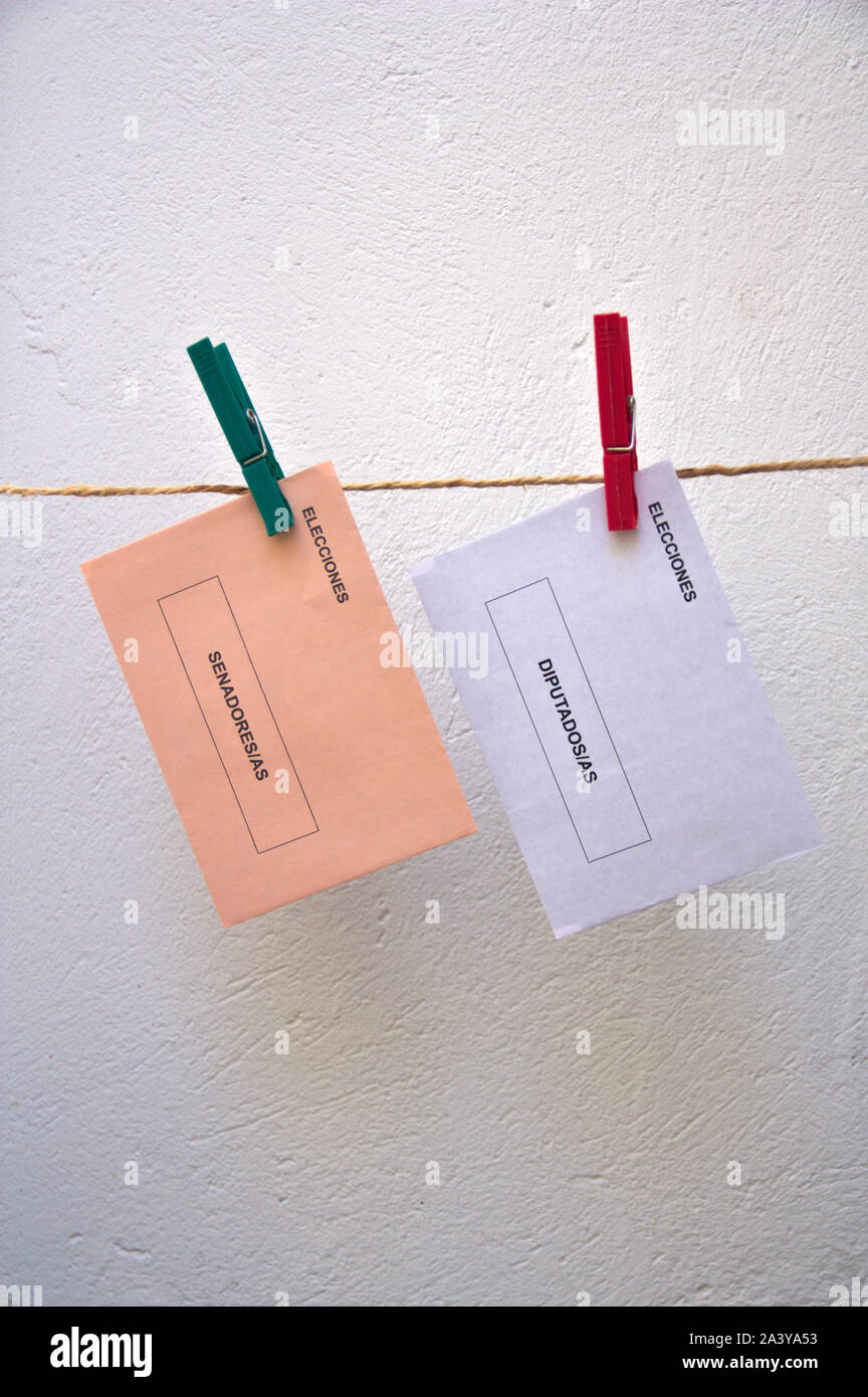 Une paire de bulletins de vote pour les élections nationales en Espagne accroché avec deux colliers sur un parcours de câble Banque D'Images