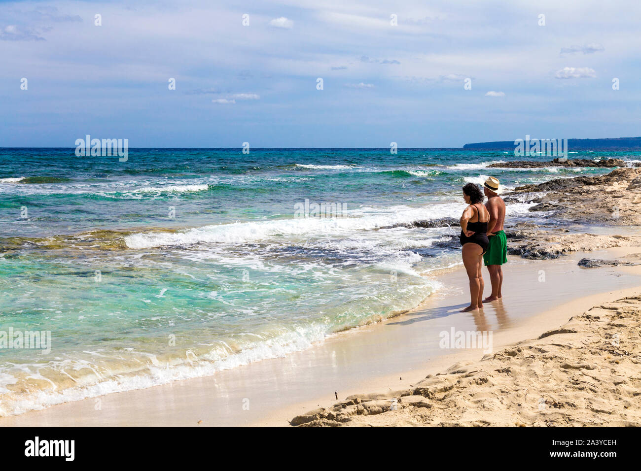 Couple debout sur la plage face à la mer sur l'île de s'Espalmador, Formentera, Espagne Banque D'Images