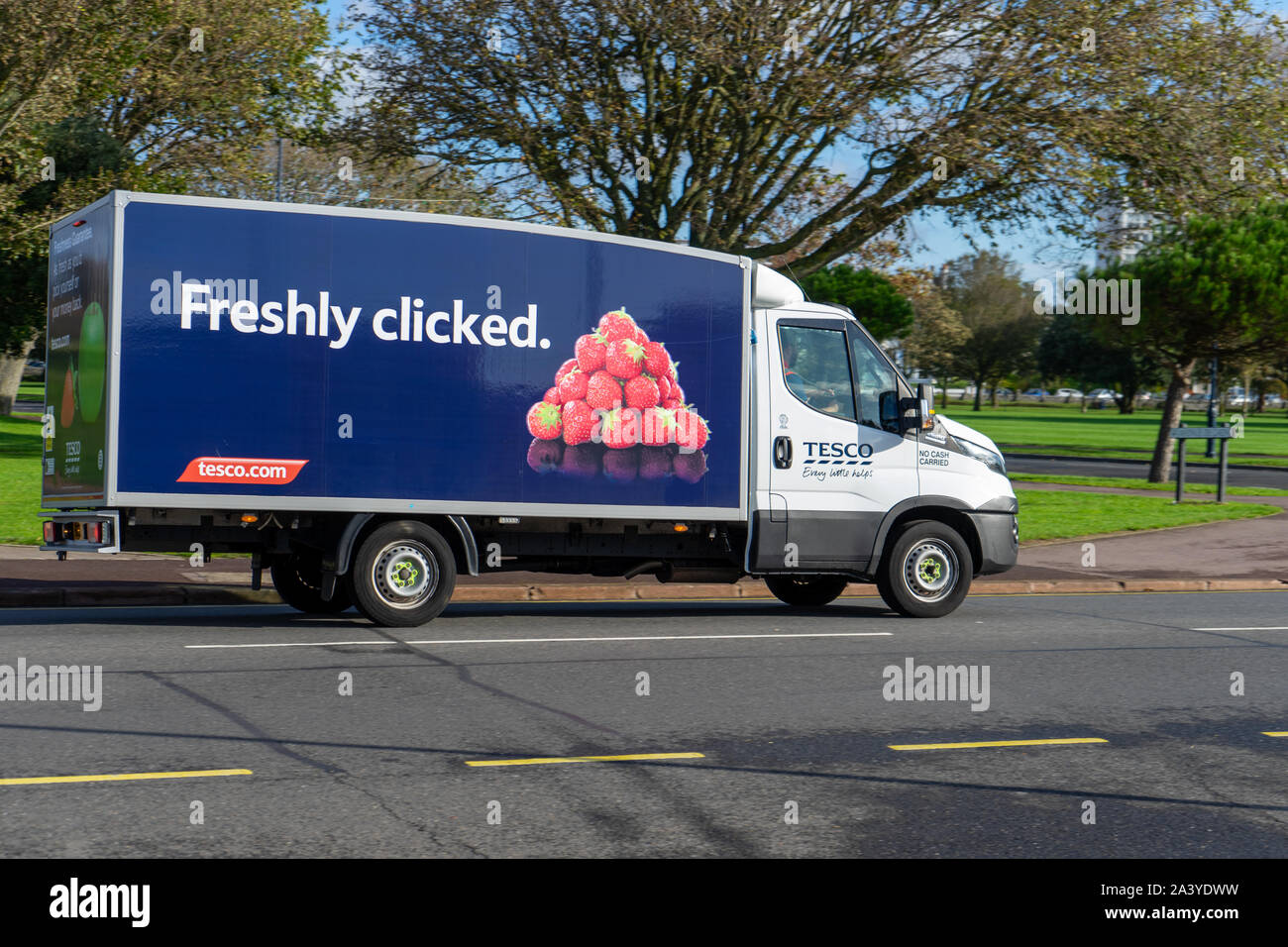 Un camion de livraison d'épicerie Tesco sur la route avec fraîchement cliqué écrit sur le côté du van Banque D'Images