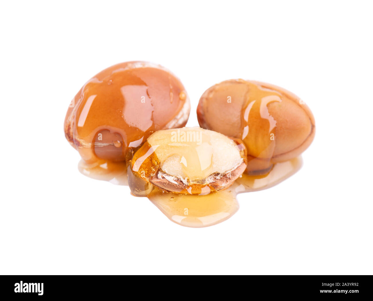 Graines d'Argan, isolé sur un fond blanc. Les noix et l'huile d'Argan cosmétique, et de produits de beauté. Fruit naturel du Maroc. Banque D'Images