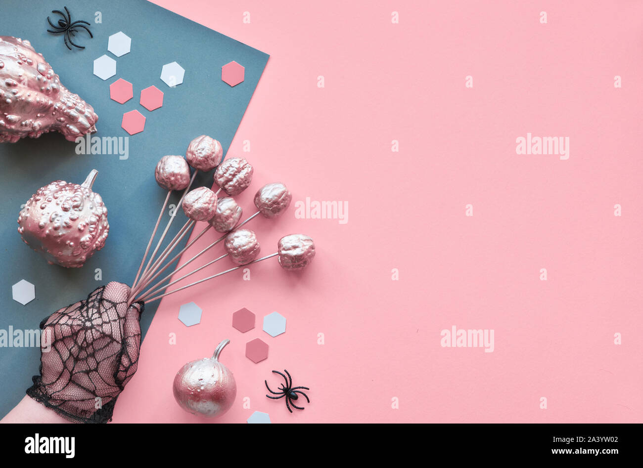 Créations en papier créatif Halloween télévision jeter sur papier rose et gris avec fond split yeux chocolat et les araignées, copiez-espace. Les mains dans les gants de maille noir Banque D'Images