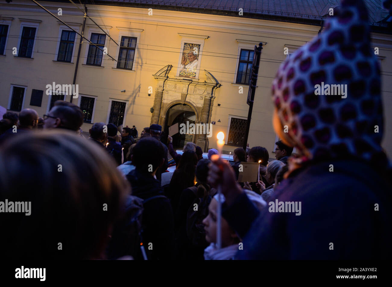 Cracovie, Pologne. 10 Oct, 2019. Un enfant est titulaire d'une bougie pendant la manifestation.protester contre l'Église Catholique de Pologne les récents discours de haine condamnant la communauté LGBT en face de la fenêtre avec le Pape Jean Paul II artwork. Au cours des derniers mois, l'Eglise catholique polonaise a appelé le mouvement LGBT la peste 'Rainbow'. L'approche des élections législatives, le gouvernement au pouvoir, Droit et Justice, a fait campagne que le mouvement LGBT est un trait à la Polish des valeurs catholiques. Credit : SOPA/Alamy Images Limited Live News Banque D'Images