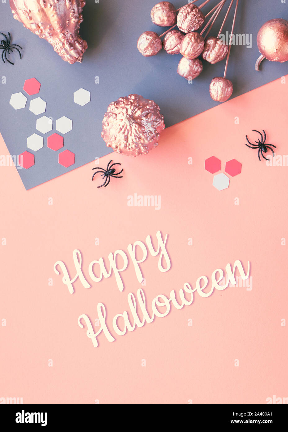 Créations en papier Halloween télévision jeter sur papier rose et gris split arrière-plan avec texte "Happy Halloween". Citrouilles peinte rose,yeux chocolat, noir spide Banque D'Images