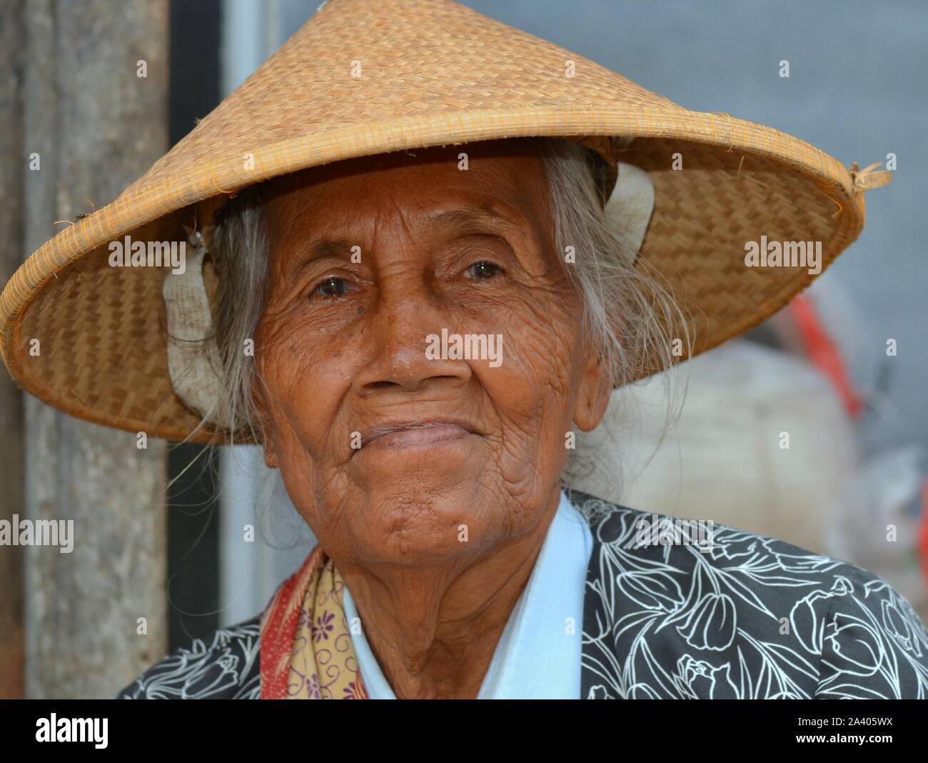 Vieux marché javanais femme porte un chapeau de paille conique asiatiques (caping). Banque D'Images
