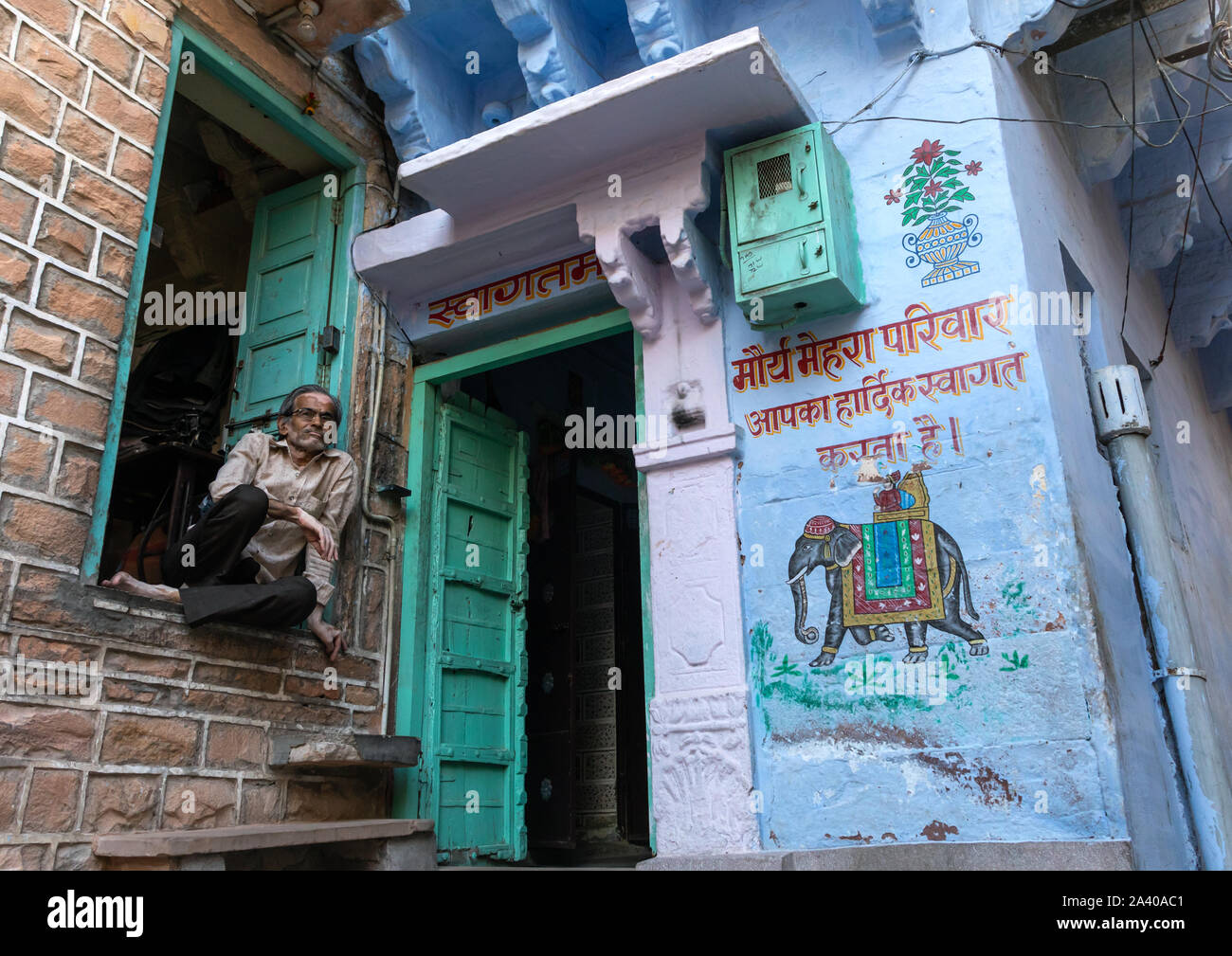 Indian homme accroupi près d'une ancienne maison bleue d'un brahmane, Rajasthan, Jodhpur, Inde Banque D'Images