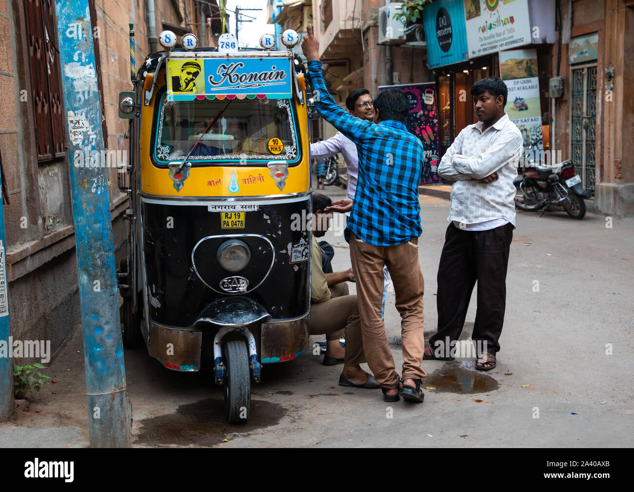 Les hommes indiens chatting près d'un rickshaw stationné en ville, Rajasthan, Jodhpur, Inde Banque D'Images