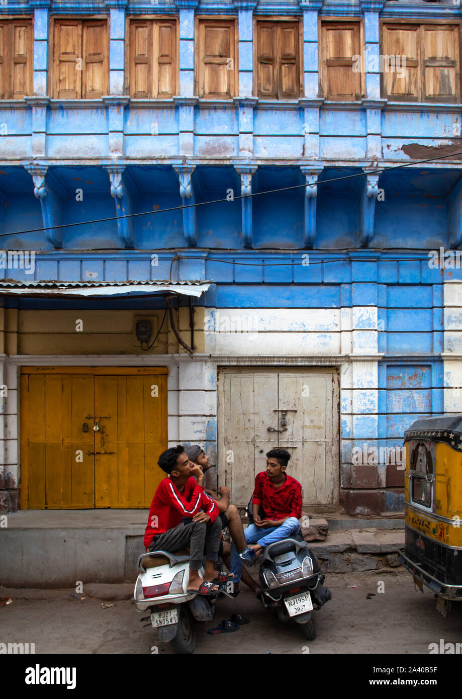 Les hommes indiens avec des triporteurs en face du vieux bleu maison d'un brahmane, Rajasthan, Jodhpur, Inde Banque D'Images
