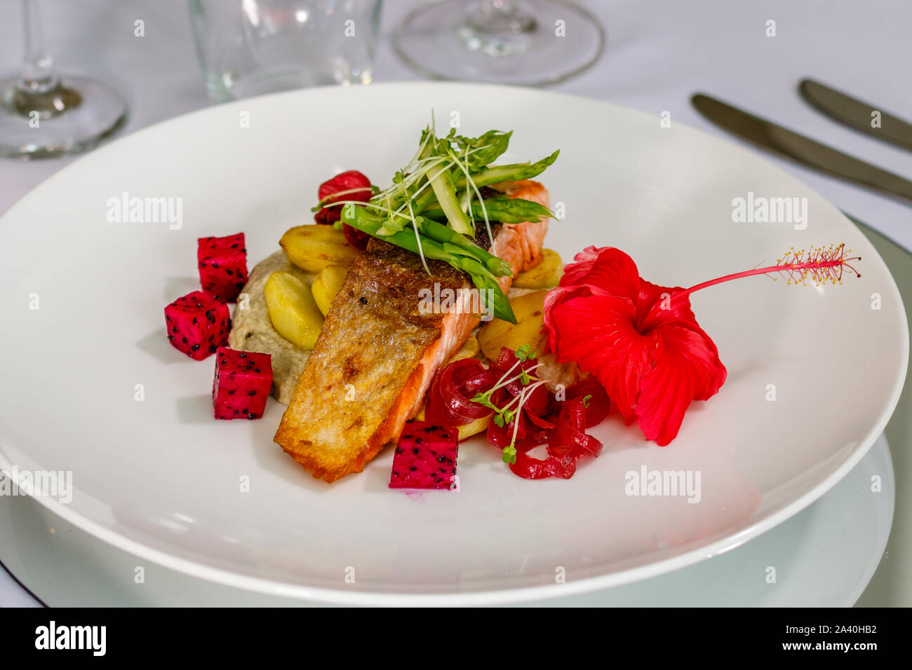 Peau croustillante avec du saumon de l'Atlantique, de pommes de terre rôties asperges sautées et Baba Ghanoush, décorées avec des fèves germées et fruit du dragon. Vue d'en haut Banque D'Images