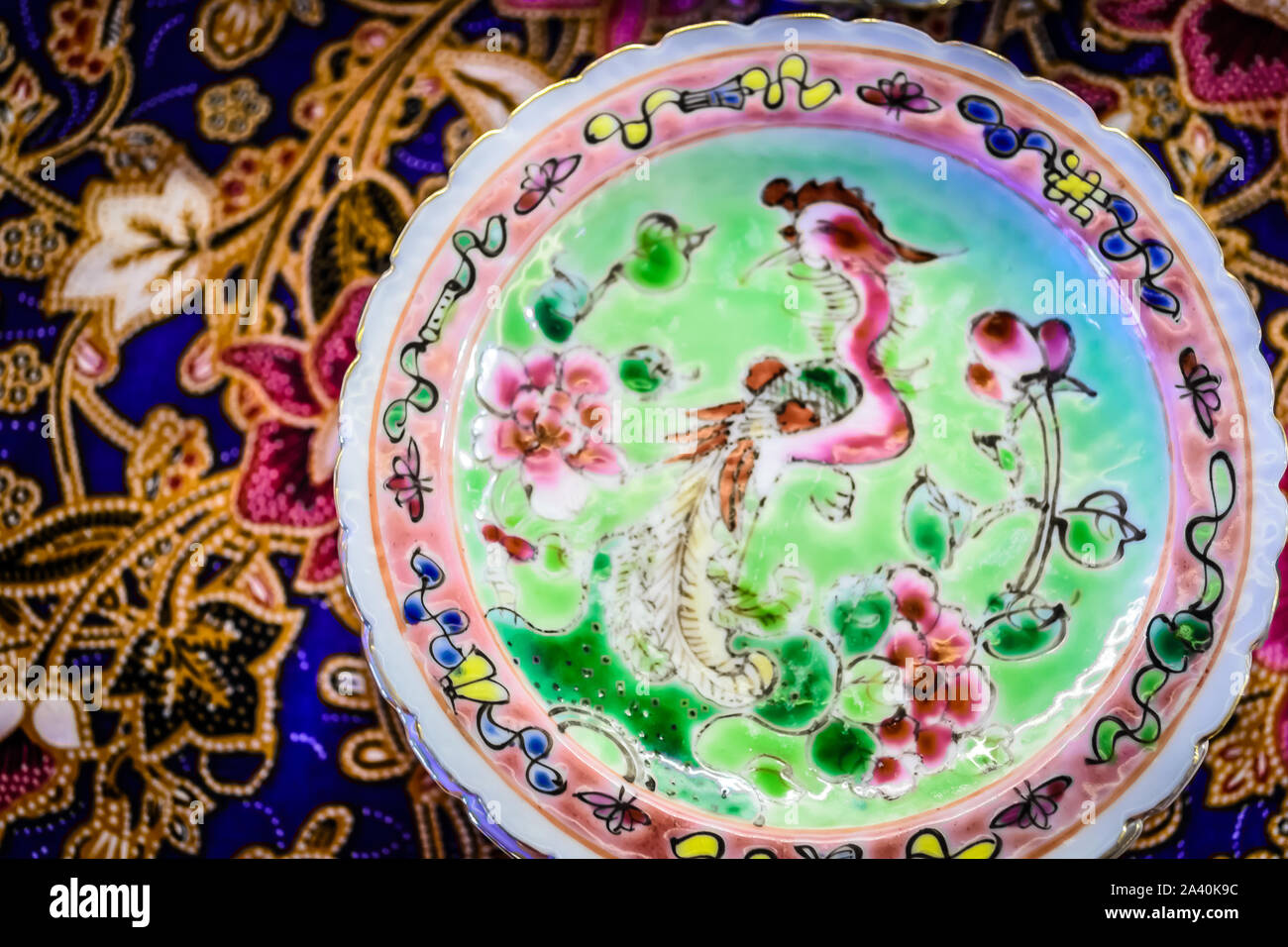 Petits plats peranakan colorés sur une table avec un chiffon coloré batik cookies peranakan typiques Banque D'Images