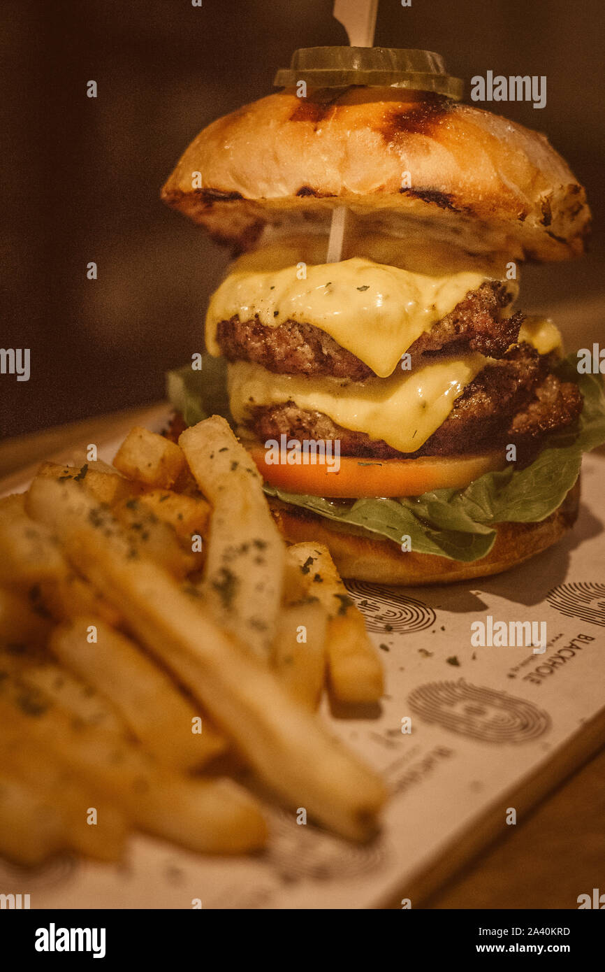 130 du boeuf gm patty, tomates, laitue romaine, le cheddar doux, l'aneth, des chips, de la relish tomate mayonnaise relish. Banque D'Images
