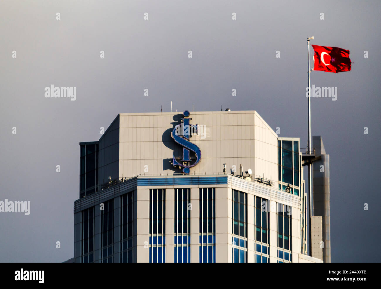 Close up du logo de Isbank avec un drapeau turc sur le toit de l'immeuble le plus de tours est complexe. Banque D'Images