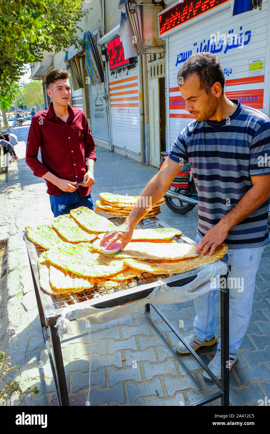 Les hommes de faire du pain (pain iranien barbari) sur une rue. Banque D'Images