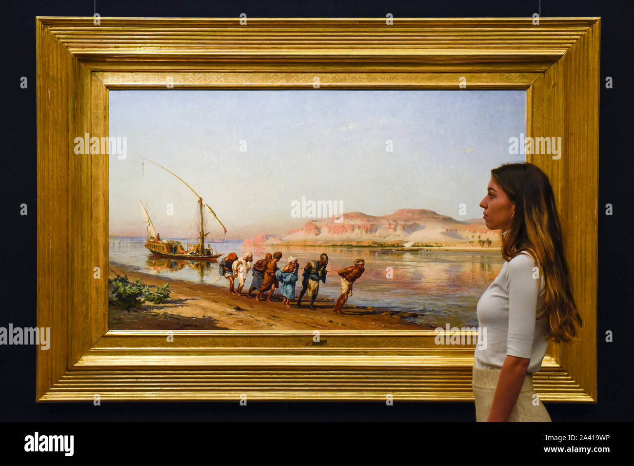 Londres, Royaume-Uni. 11 octobre 2019. Un membre du personnel vues 'Le remorquage sur le Nil", 1875, par Frederick Arthur Bridgman,500-700k GBP (Est). Essai d'œuvres de la collection de peintures orientalistes Najd chez Sotheby's à New Bond Street, qui enregistrent la vie quotidienne dans le quartier historique, arabe et islamique Ottoman tous les 155 peintures sont à la vue du public 11- 15 octobre, avec 40 oeuvres qui seront mises aux enchères le 22 octobre. Crédit : Stephen Chung / Alamy Live News Banque D'Images