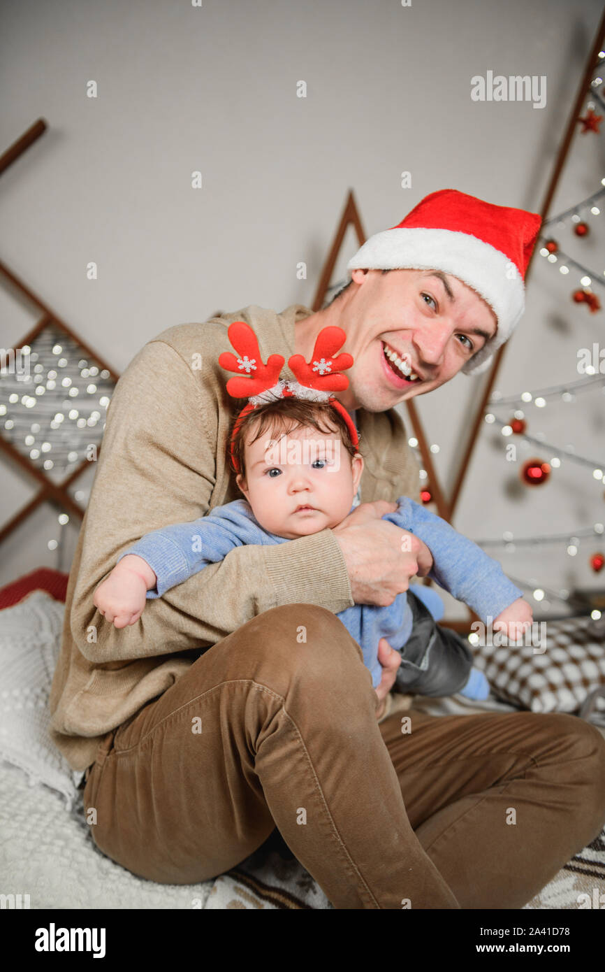 Papa avec son fils serrant et s'amusant. L'amour, le bonheur et le concept d'une grande famille. père et fils s'amuser dans la nouvelle année. Décoration Nouvel An. Banque D'Images