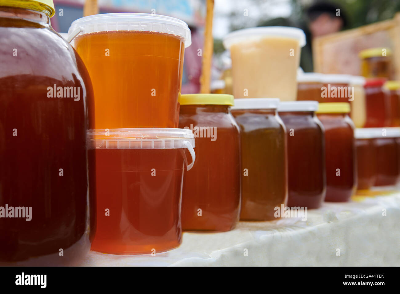 Beaucoup de pots avec différents types de miel au marché. Maison saine produit sur la table. Orange, orange et brun avec des liquides. Activités d'une beeke Banque D'Images