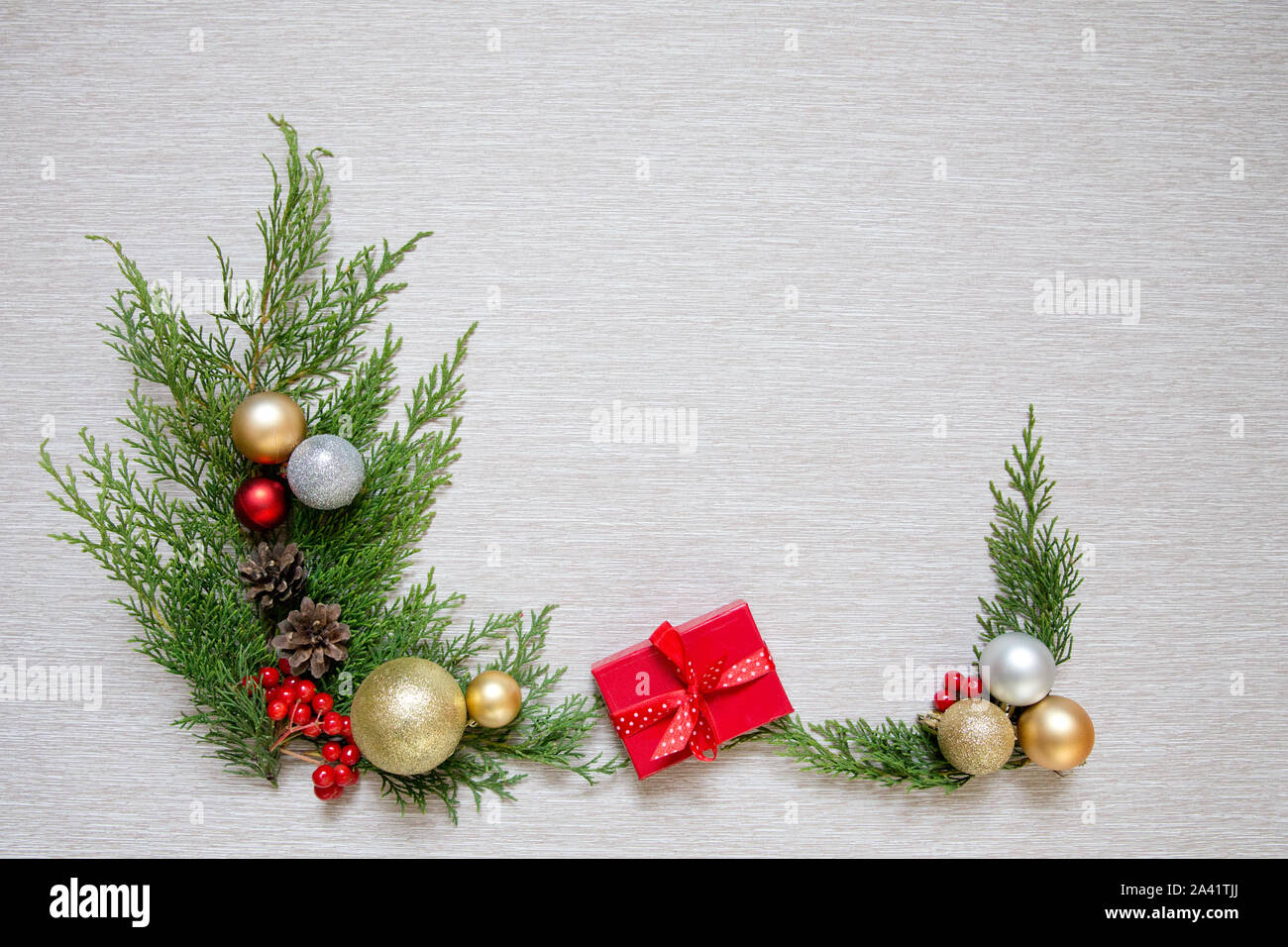 Branches vertes et des boules de Noël. Décoration de Noël sur un fond clair. Cadeau du Nouvel An dans une petite boîte rouge. Banque D'Images