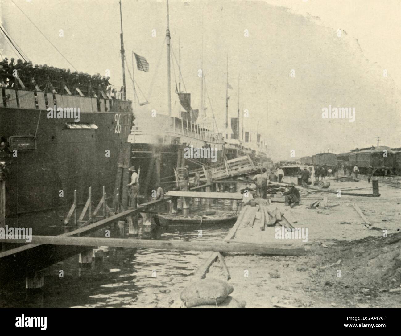 'Au quai, le 10 juin, la guerre hispano-américaine, 1898, (1899). Les navires dans le port de Port de Tampa, Floride, USA. Ils prenaient les troupes américaines à Cuba. À partir de "La Petite J'ai vu de Cuba" par Burr McIntosh, avec des photographies de l'auteur. (En 1898, l'acteur américain et journaliste William Burr McIntosh est allé à Cuba pour couvrir la guerre hispano-américaine pour "Leslie's Weekly" comme journaliste et photographe). [F. Tennyson Neely, Londres &AMP ; New York, 1899] Banque D'Images