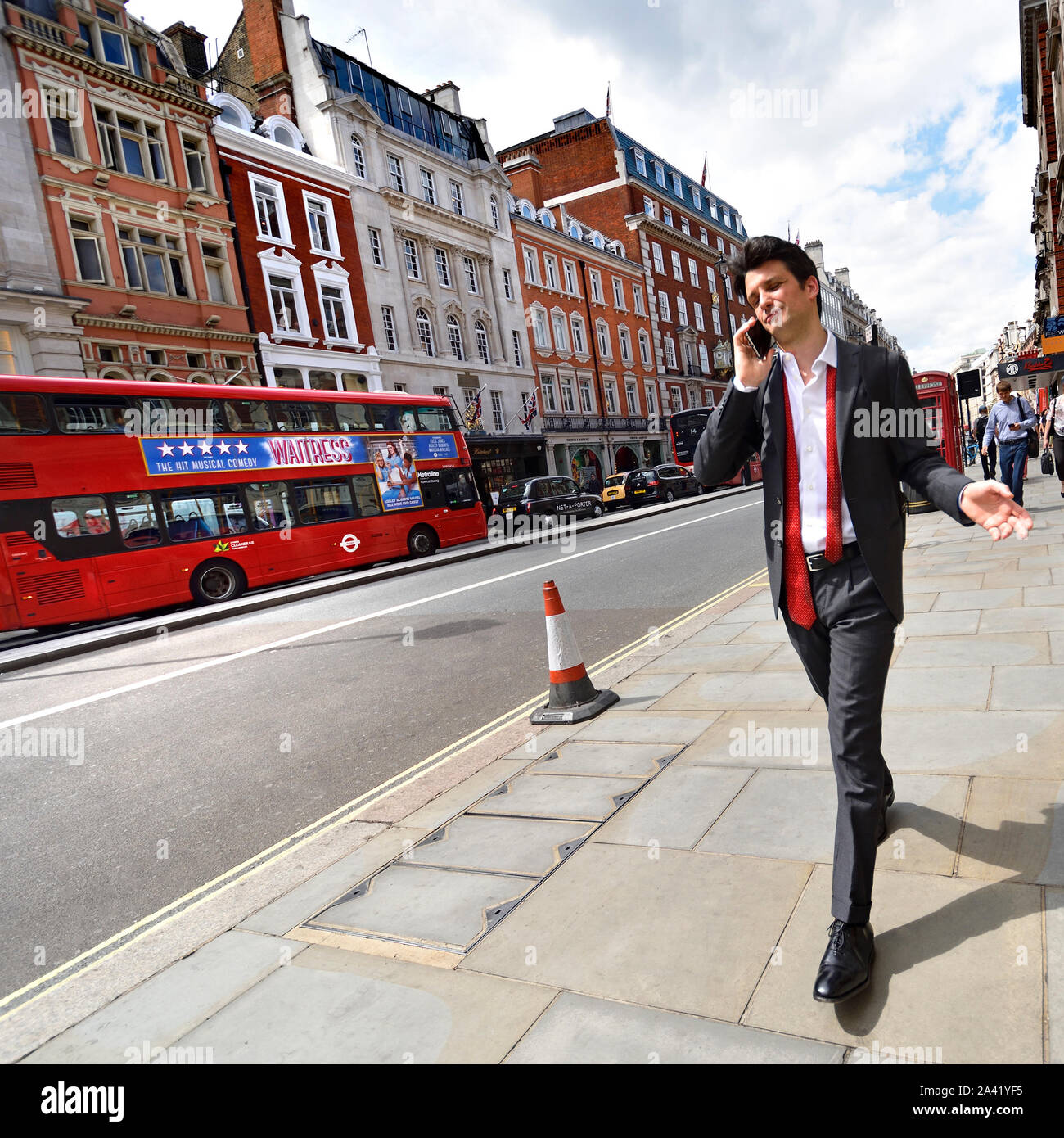 Londres, Angleterre, Royaume-Uni. Jeune homme élégant sur son téléphone mobile Banque D'Images