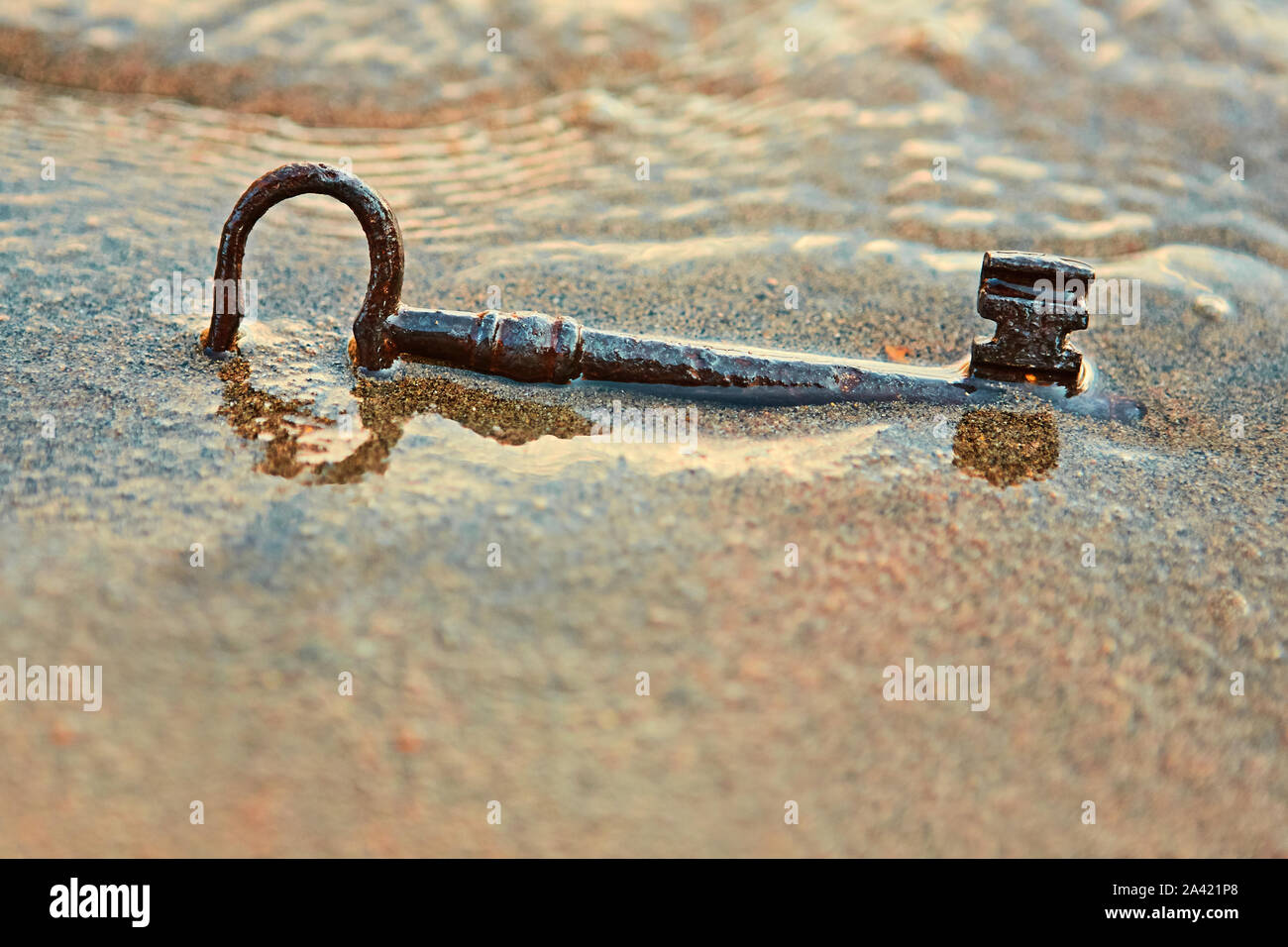L'océan a jeté une ancienne clé de fer sur la plage. Quel secret cache cette touche n. Dont les mains avaient fermé leurs coffres au trésor il y a des siècles. Banque D'Images