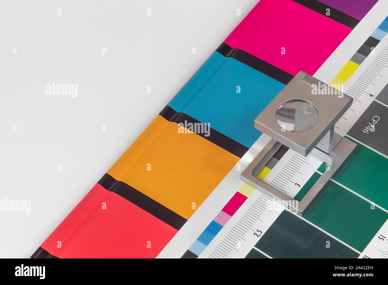 Loupe d'argent sur l'impression test permanent, l'arrière-plan de couleur. Loupe d'impression offset sur feuille imprimée avec des couleurs de base des barres de commandes. Banque D'Images