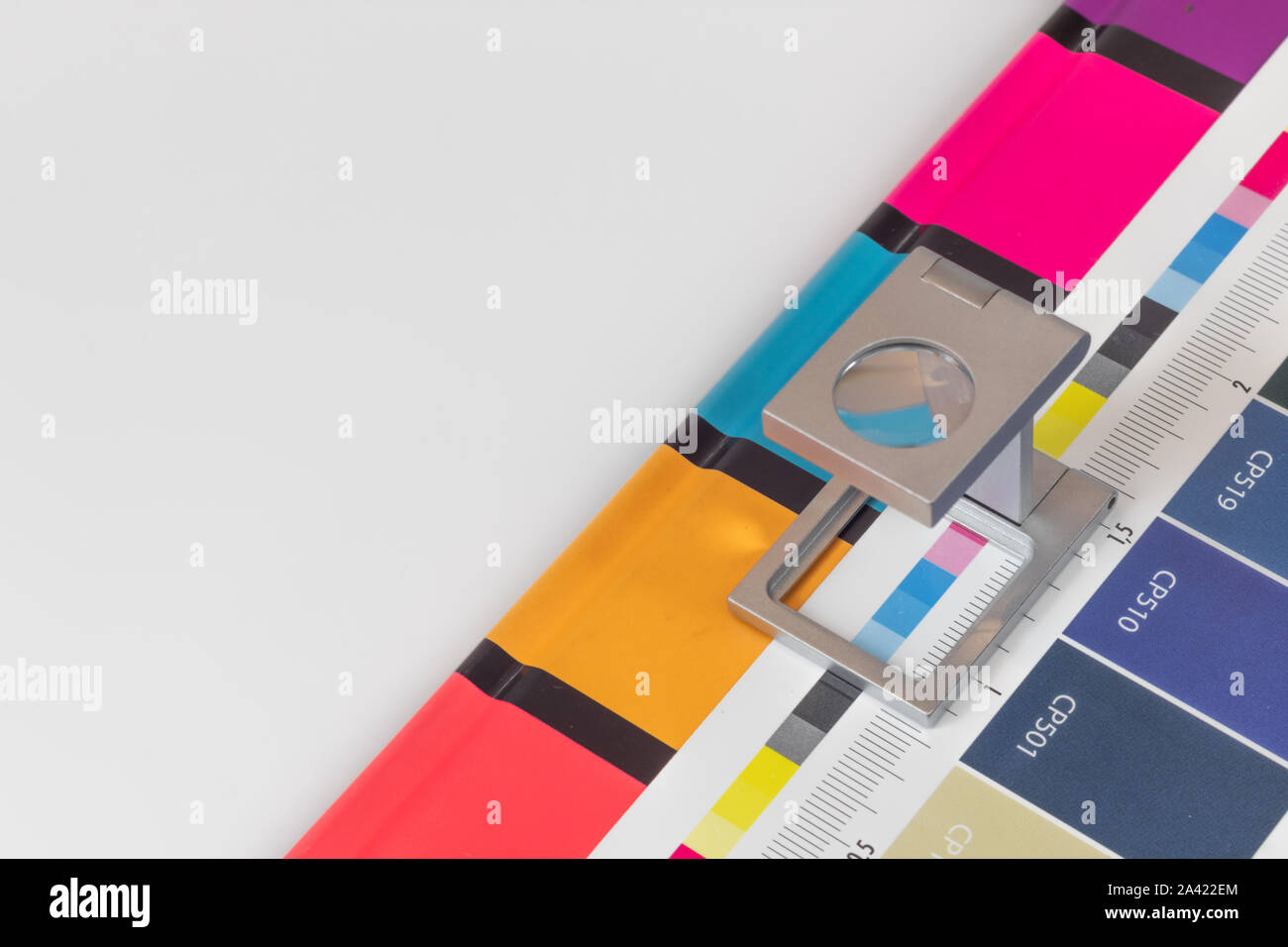 Loupe d'argent sur l'impression test permanent, l'arrière-plan de couleur. Loupe d'impression offset sur feuille imprimée avec des couleurs de base des barres de commandes. Banque D'Images