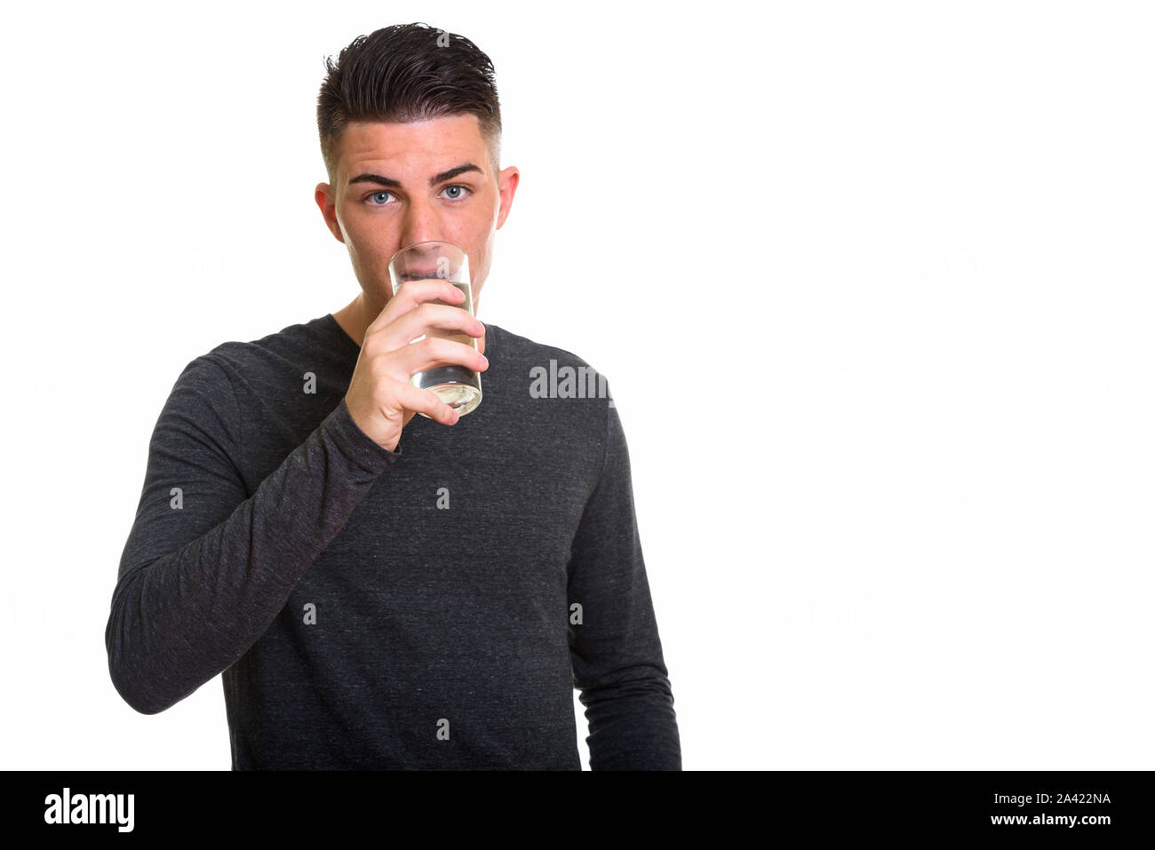 Studio shot of young man drinking glass of water Banque D'Images