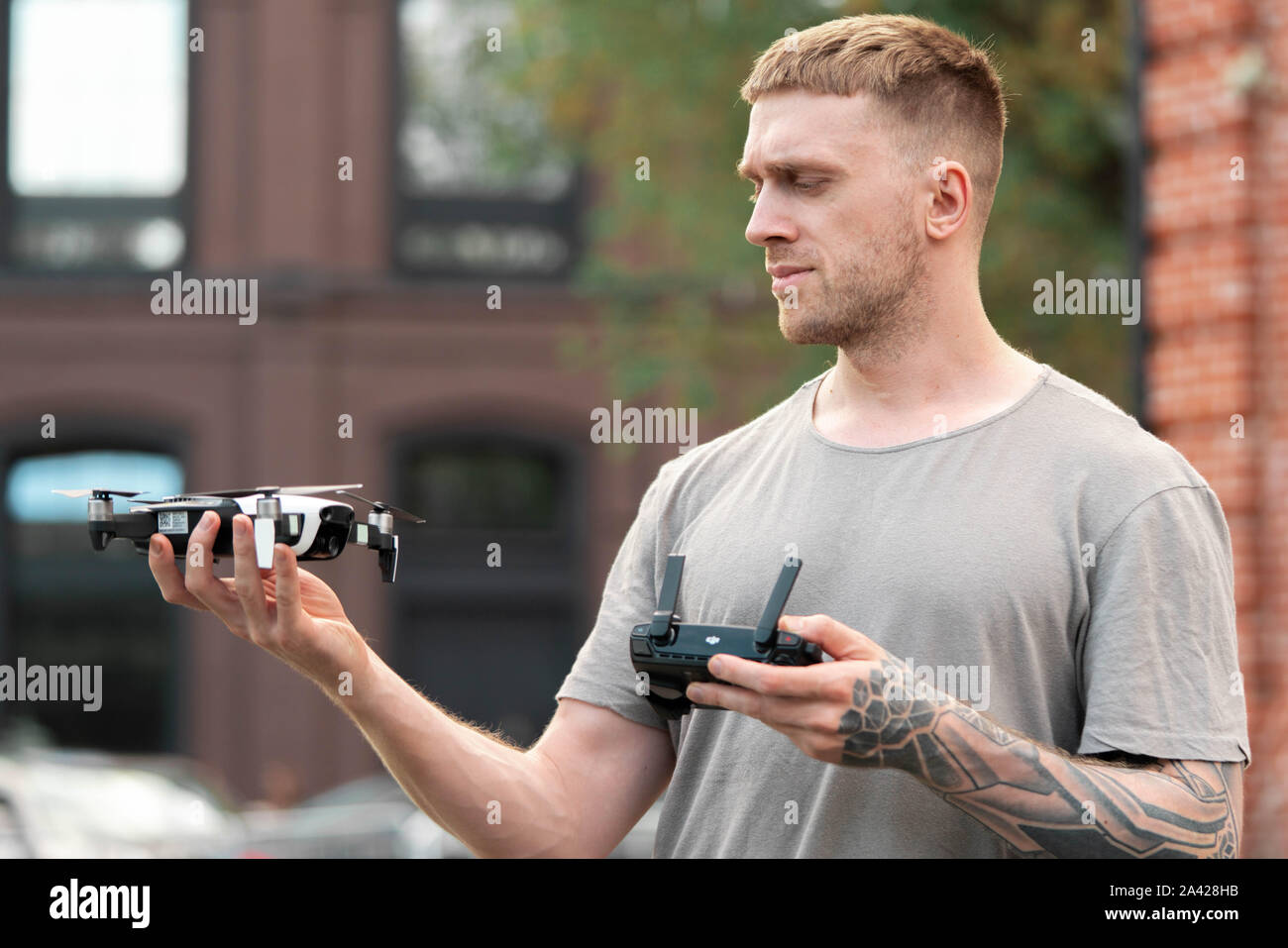 Jeune homme séduisant le lancement de drone quadcopter au contexte urbain. paysage urbain. appareil moderne pour faire de la vidéo Banque D'Images