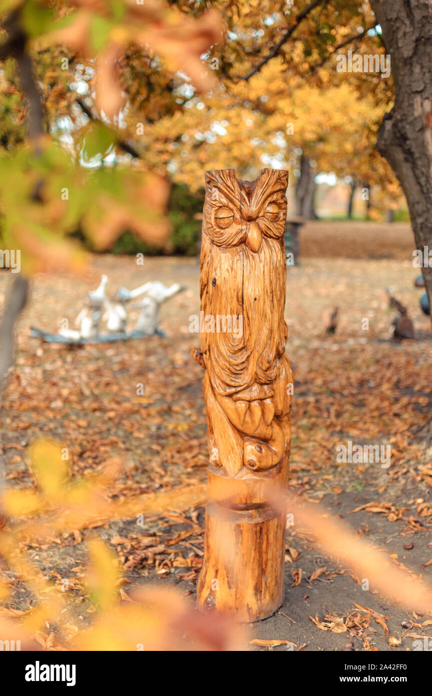 Chouette en bois dans un totem forest park. Les arbres sont visibles sans doute du même type à partir de laquelle les statues sont taillées. Des sculptures en bois d'une idole dans un Banque D'Images