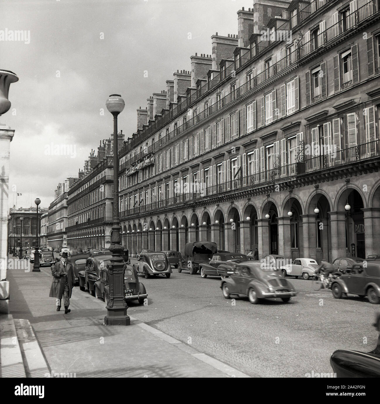 Années 1950, historiques, l'automobile de l'époque de la rue de Rivoli, Paris, France, une célèbre rue qui longe l'aile nord du Palais du Louvre et avec son extérieur façade à arcades au niveau du sol. Banque D'Images