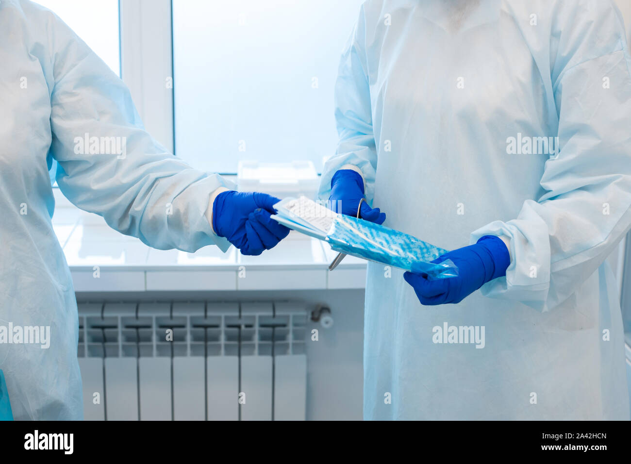 Une infirmière ouvre un sac avec un instrument stérile à usage unique avant une chirurgie. Banque D'Images