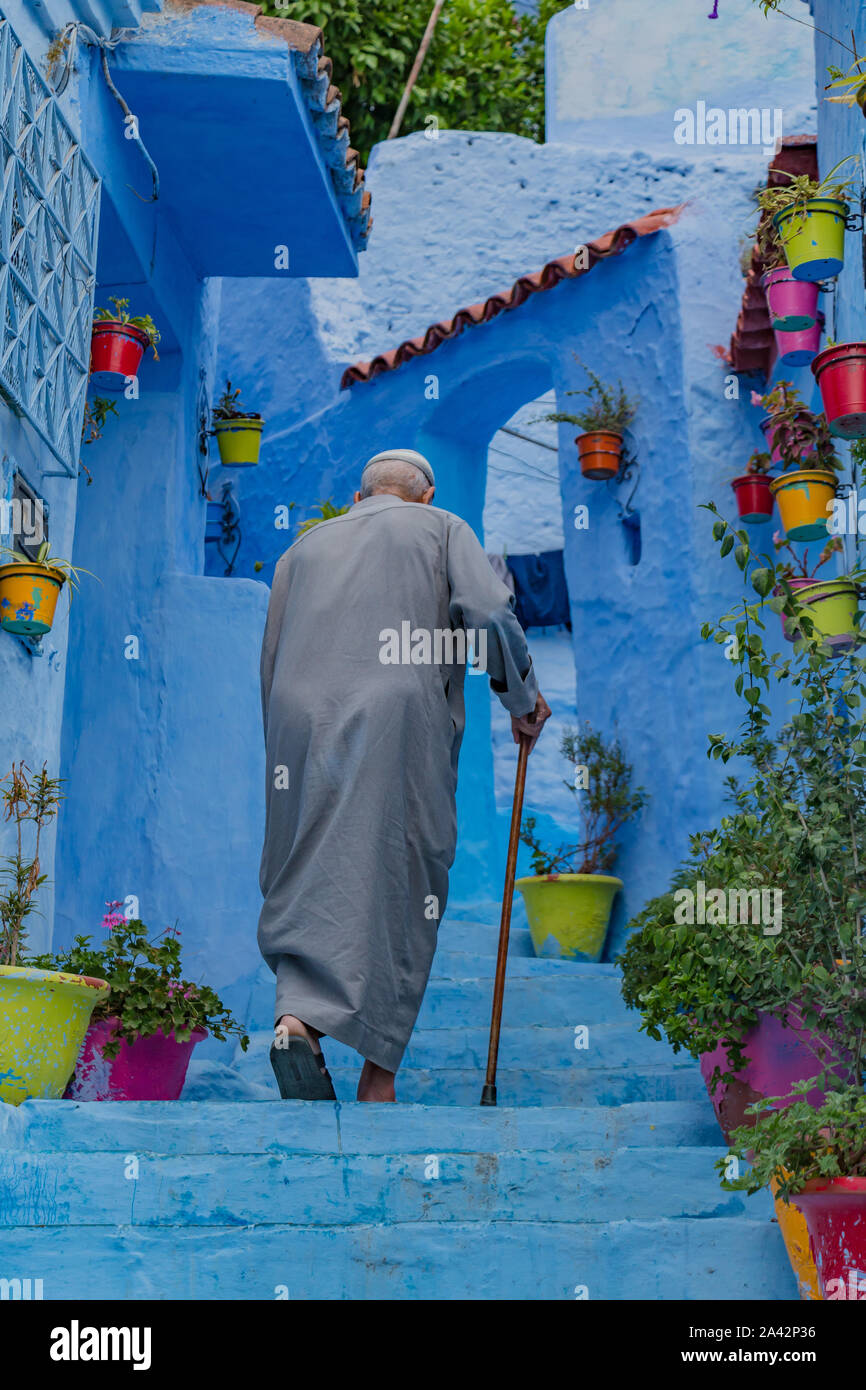 Une photo d'un homme âgé qui monte un escalier à Chefchaouen. Banque D'Images