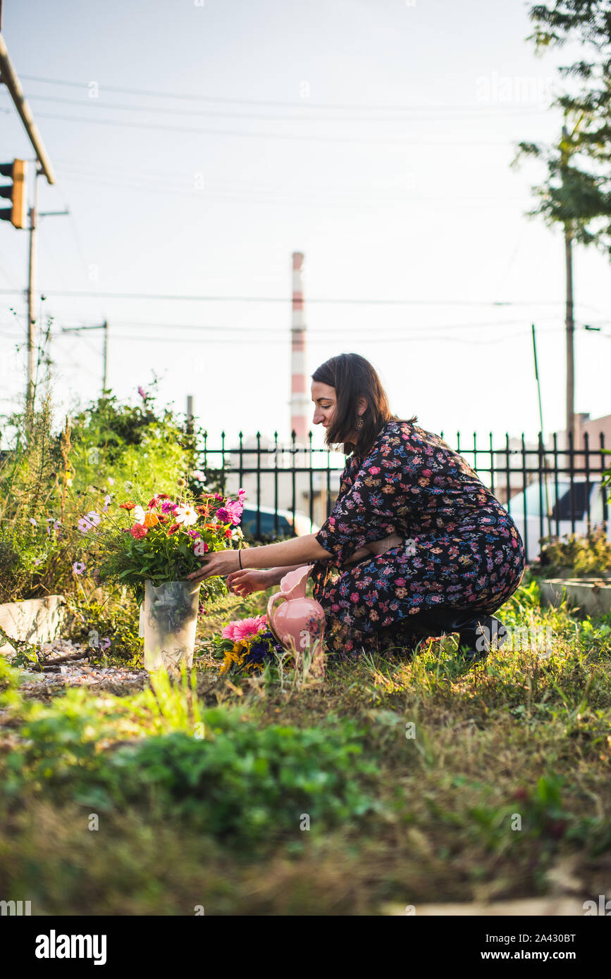 Happy woman in an urban flower garden Banque D'Images