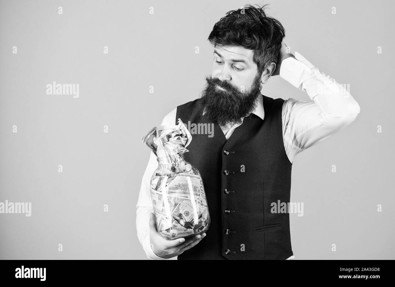 Ce qui est une bonne façon d'investir de l'argent. Homme barbu pense à investir de l'argent dans les affaires. Le calcul de ses affaires de flux futurs de trésorerie provenant des activités d'investissement. Investir dans l'avenir, l'espace de copie. Banque D'Images