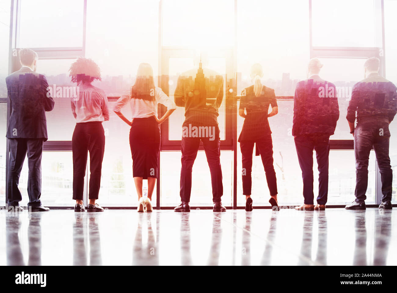 Contexte Concept avec des gens d'affaires d'ossature en regardant par la fenêtre dans un bureau moderne. Double exposition Banque D'Images