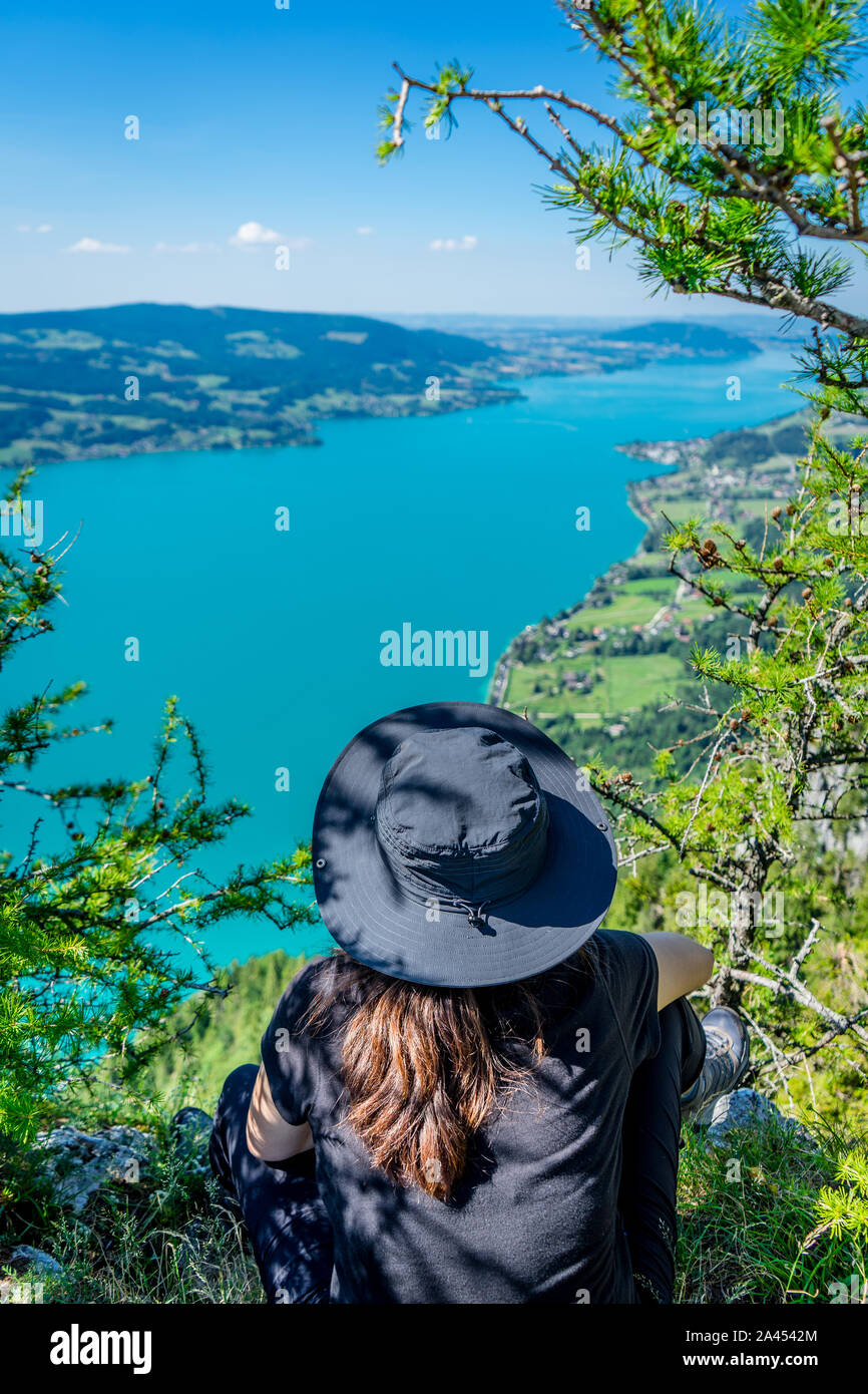 Fille avec un chapeau au mont Schoberstein relaxant et à la recherche jusqu'au lac Attersee (Dossier) dans les Alpes, Autriche Banque D'Images