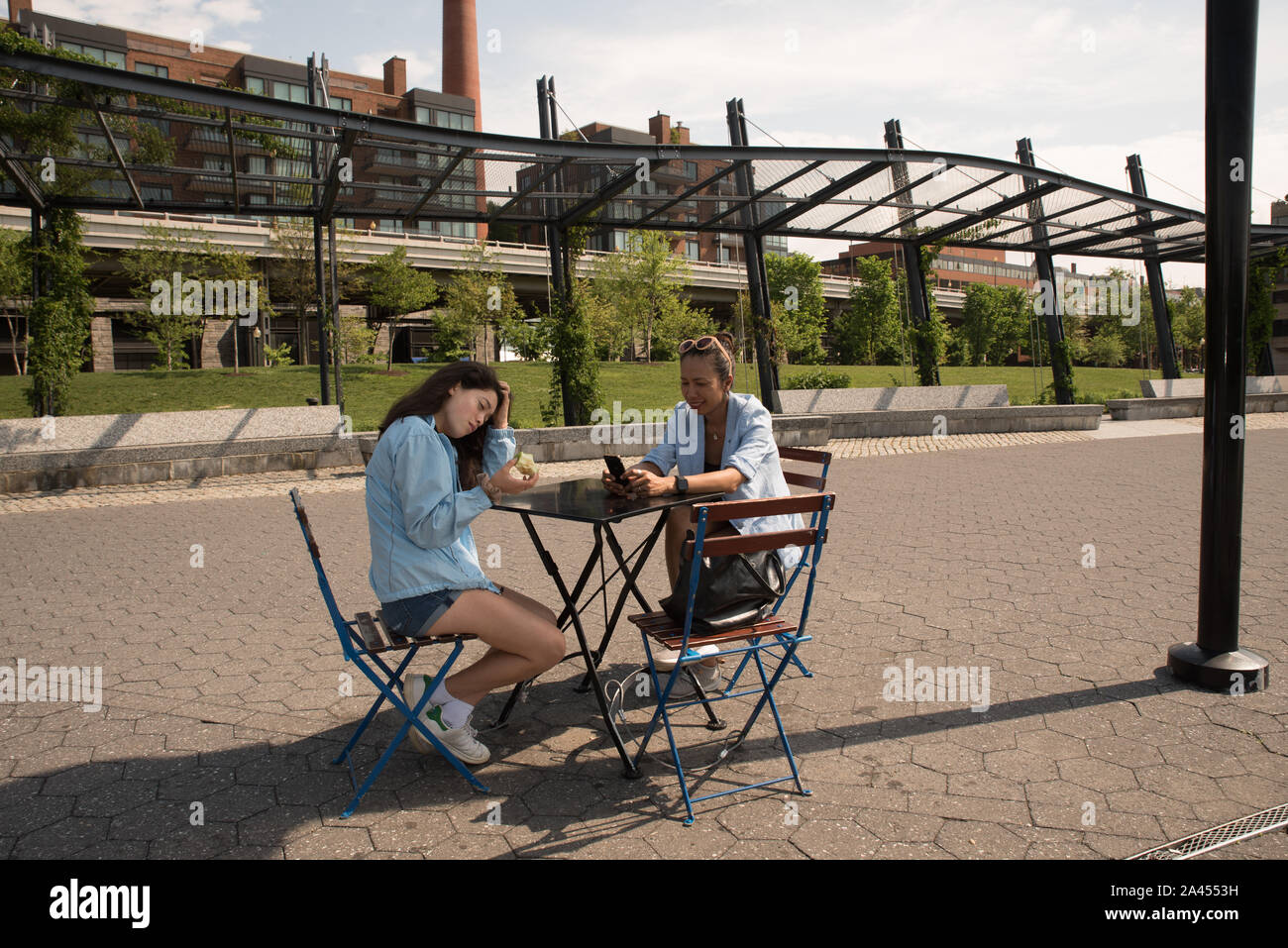 La mère et la fille assis à table avec café Blue Jackets et le parc à l'arrière-plan Banque D'Images