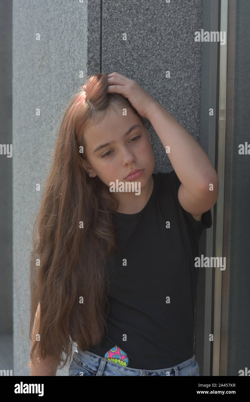 Les jeunes adolescents Européens bouclés brunette model posing.adolescentes dans un T-shirt noir. Fille de 10 ans qui posent sur la véranda dans un café ou sur l'affaire BALCO Banque D'Images