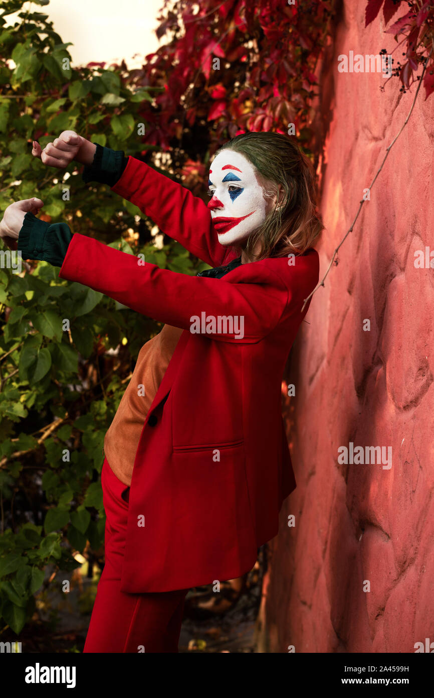 Jeune femme avec Joker le maquillage et costume, danse Banque D'Images