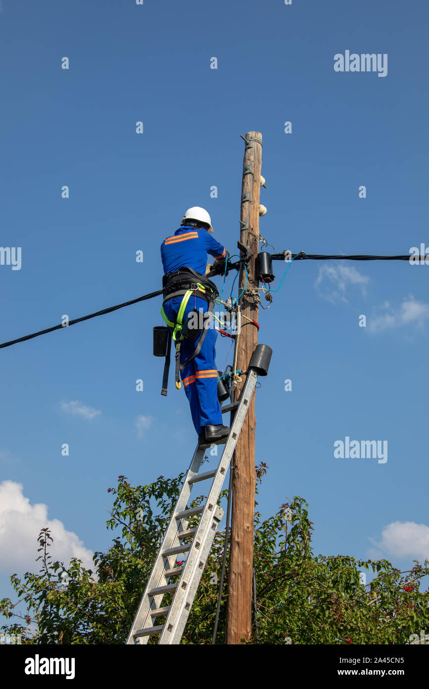 Électricien Motswana travailleur dans un Botswana , travailler sur un poteau pour réparer une panne Banque D'Images