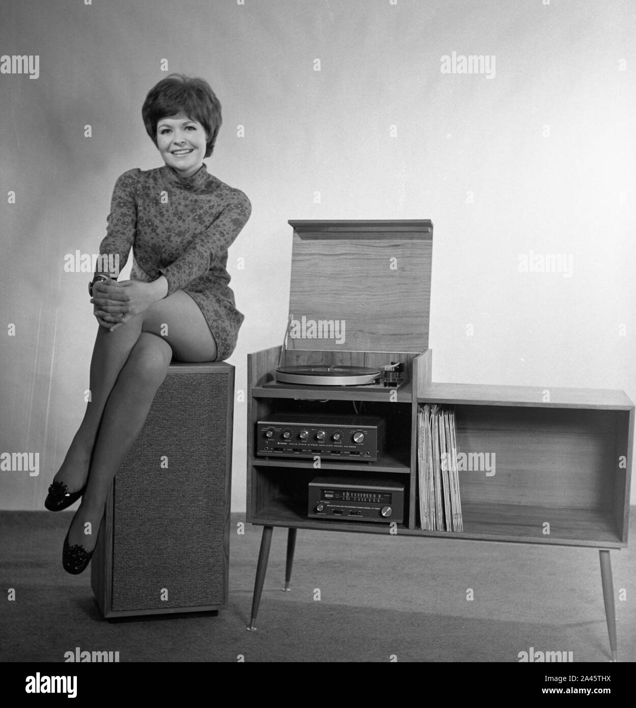 Modèle avec cheveux courts pose dans une mini-robe avec son stéréo c1969 Photo de Tony Henshaw Archive Banque D'Images