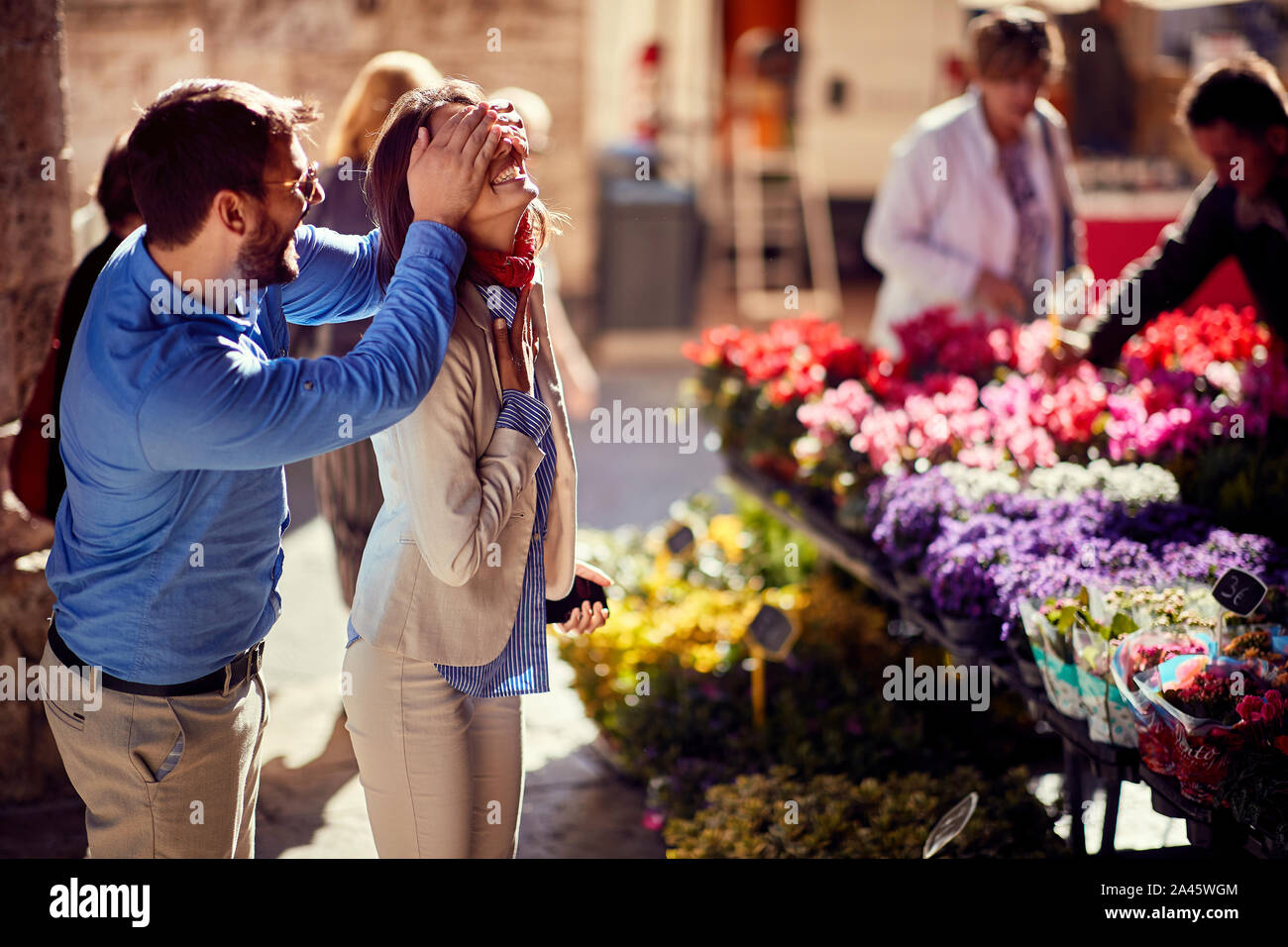 L'achat de fleurs.Man surprises happy woman flower shop dans la rue. Banque D'Images