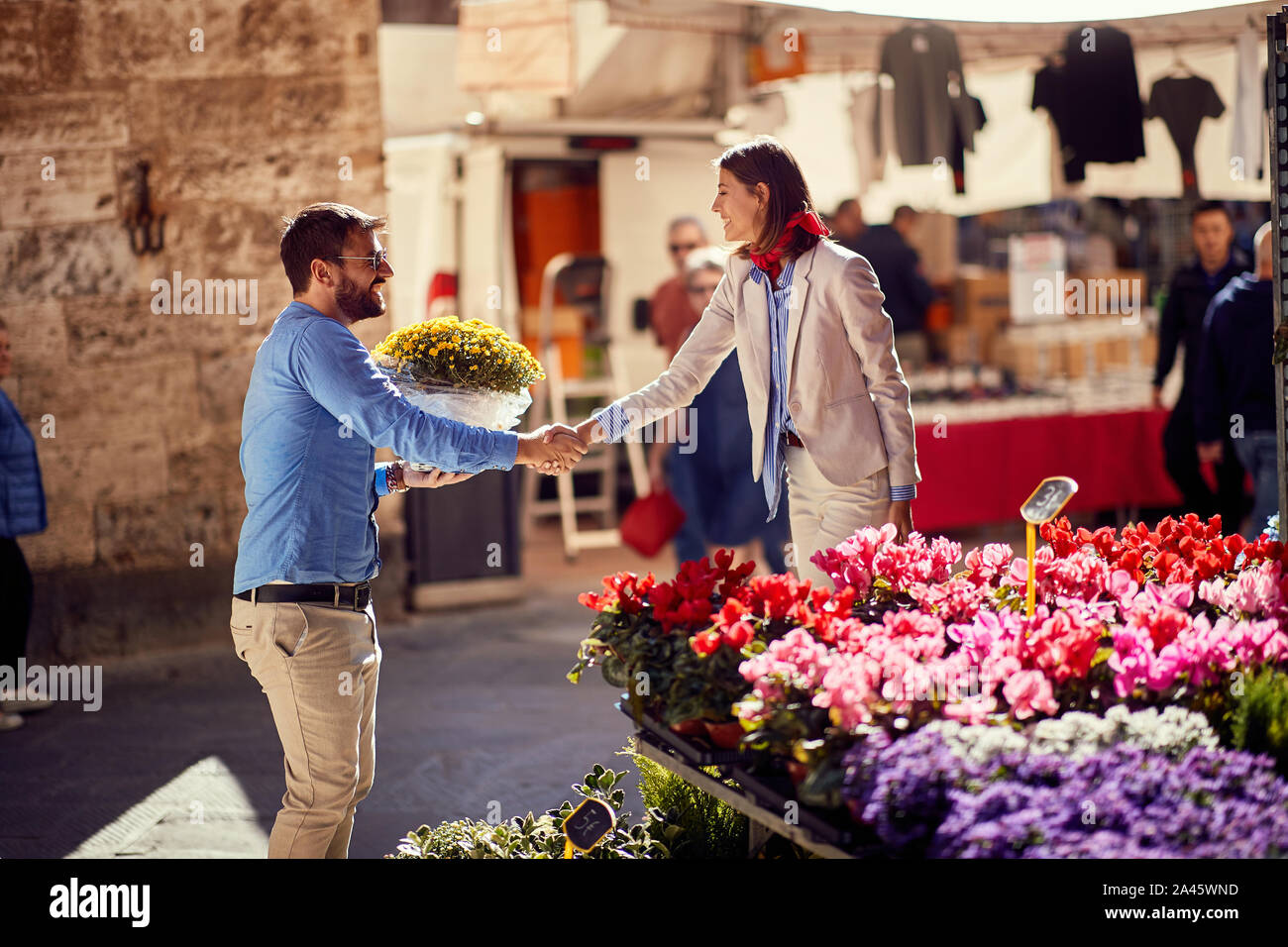 Happy woman shopping pour les plantes à fleurs sur la rue. Banque D'Images