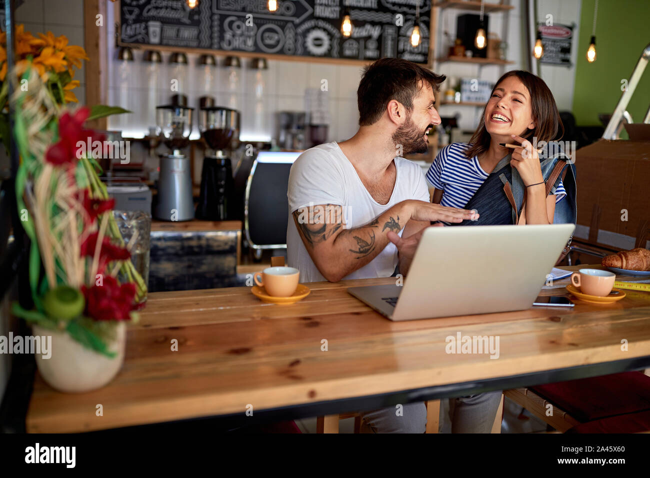 Propriétaire souriant dans un coffee shop. Propriétaire de petite entreprise. Happy man and woman working in coffee shop. Banque D'Images