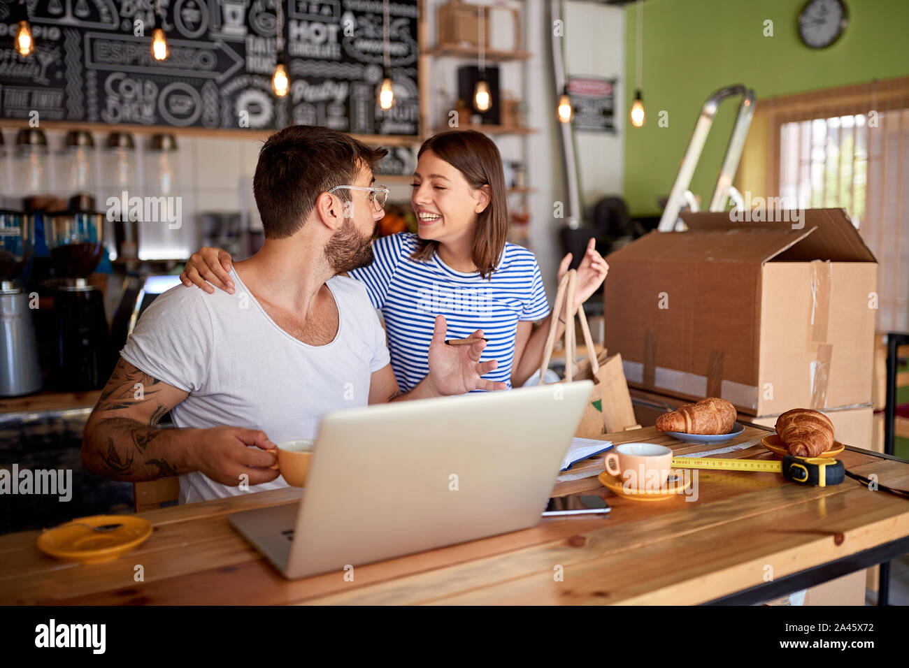 Café.affaires. Smiling business owner in working on laptop. Banque D'Images